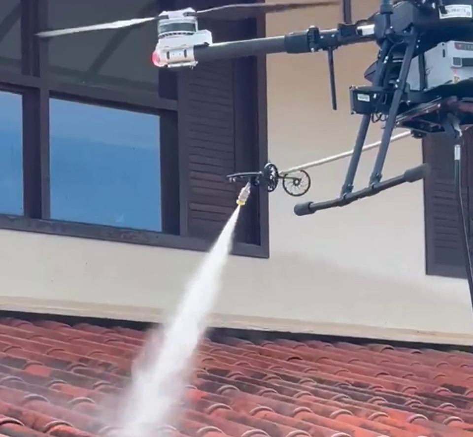 Drone da ALTI aplicando jato de alta pressão em telhado